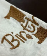 Macro close-up of dense logo embroidery stitching on corporate polo fabric
