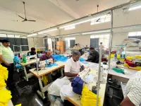Workers stitching polo t-shirts at sewing stations on the Anuvavi partner factory floor in Tiruppur