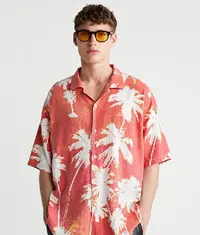 A man wearing a colourful oversized shirt in red and white colour