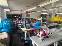 Anuvavi Apparels partner t-shirt manufacturing unit in Tiruppur, with garments moving through the stitching line