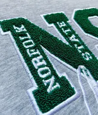 A close up image of a t shirt with a beautiful chenille embroidery design